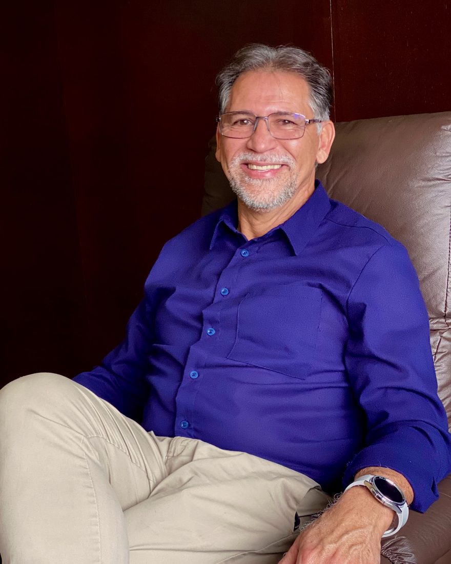 John Macedo, psicanalista e terapeuta, sentado em uma poltrona de couro