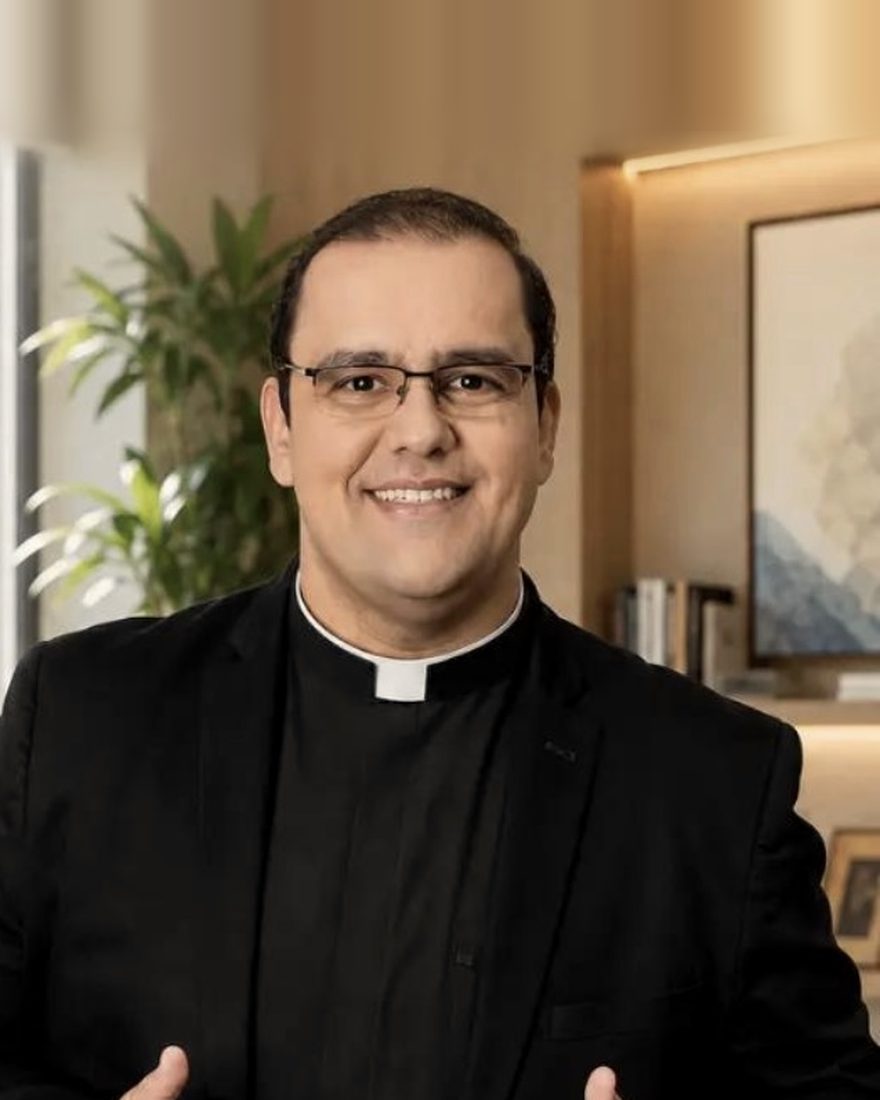 Padre Renato, sorrindo em um consultório